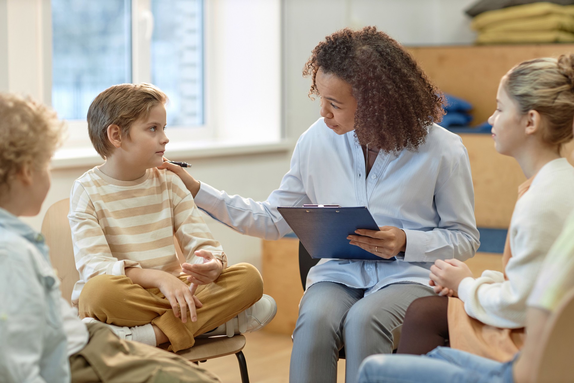 Female Psychologist Comforting Boy in Support Group